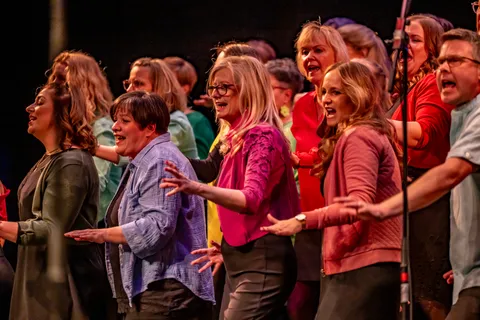Sängerinnen von colorsounds singen und tanzen in bunten Outfits auf der Bühne