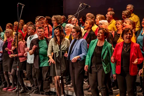 Die erste Reihe des Chors colorsounds singt in bunten Jacken