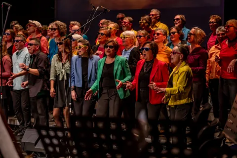 Der Chor colorsounds singt mit bunten Sonnenbrillen während eines Songs